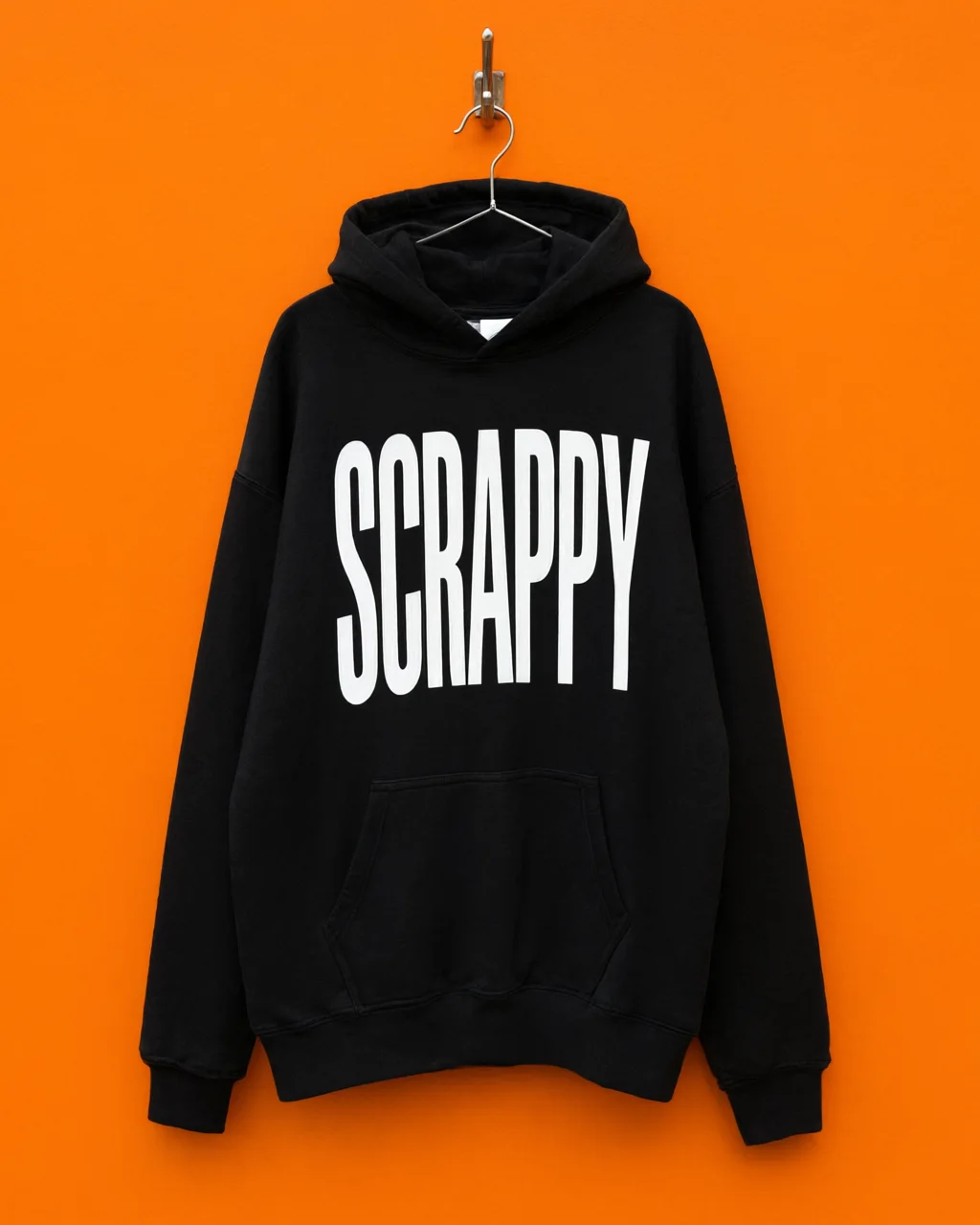 Black SCRAPPY hoodie on an orange wall